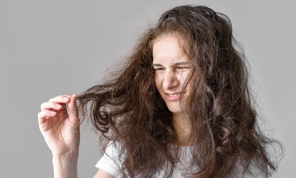 دختری جوان که از وزی موهایش کلافه است | درمان وز شدن مو