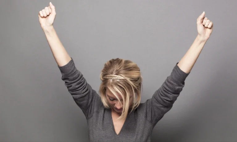 خانمی جوان که دستانش را به نشانه موفقیت مشت کرده است | افزایش عزت نفس