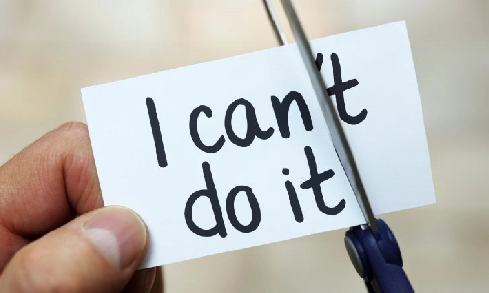 فردی در حال برش یک کاغذ با قیچی | افزایش عزت نفس