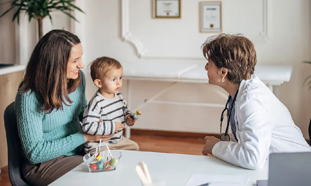 مادری که کودکش را نزد پزشک برده است | علائم اوتیسم