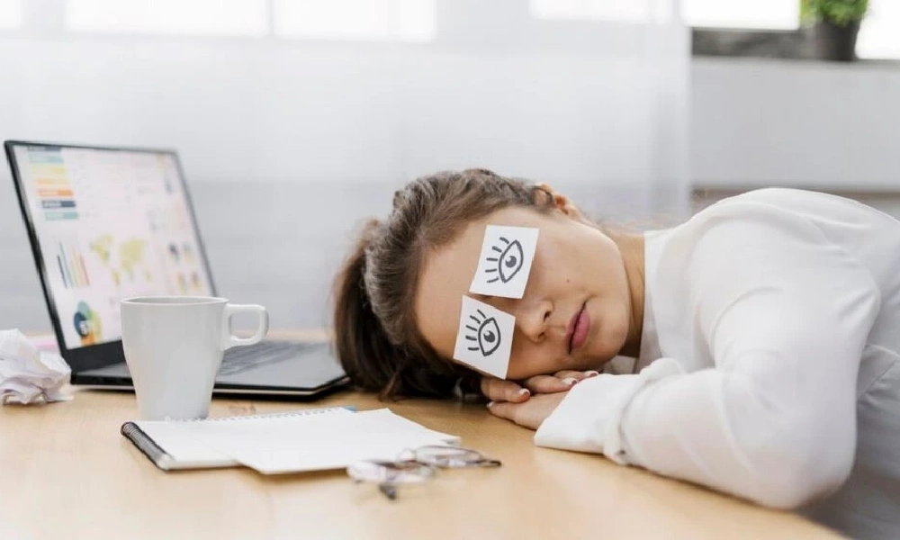 خانمی که حین کار با لپ تاپ خوابش برده است | علائم کمبود منیزیم
