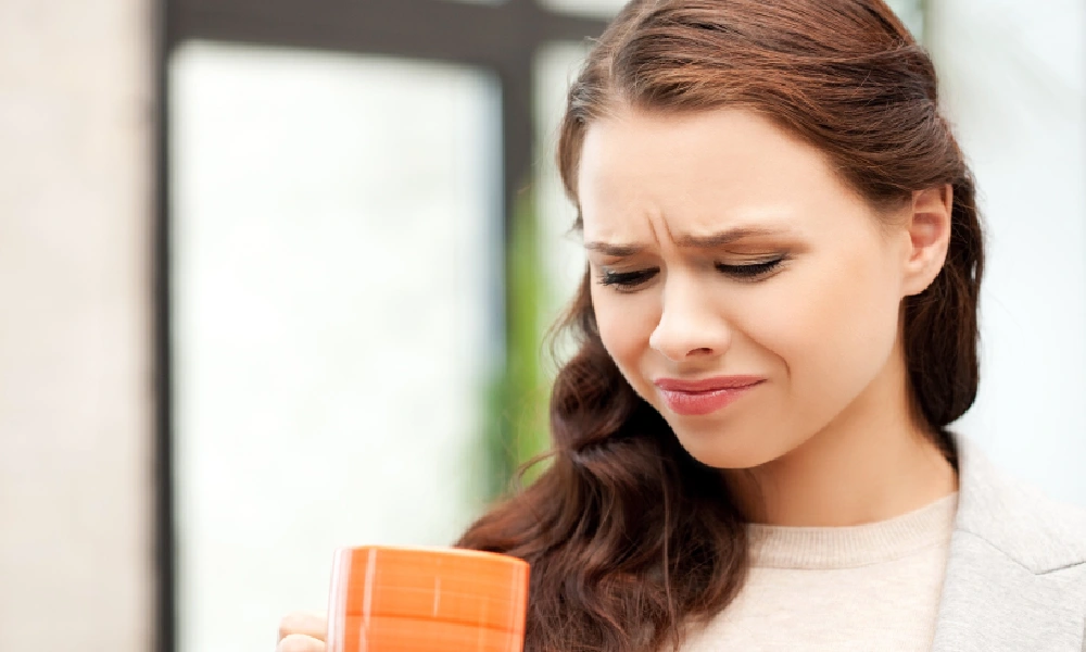 علت تلخی دهان | خانمی که ددر حال خوردن یک نوشیدنی تلخ است