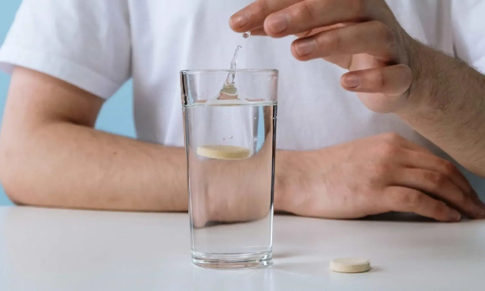 فردی در حال انداختن یک قرص جوشان در لیوان | انواع قرص جوشان