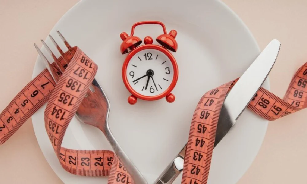 فواید رژیم فستینگ یک متر خیاطی در یک بشقاب و در کنار چاقو و چنگال